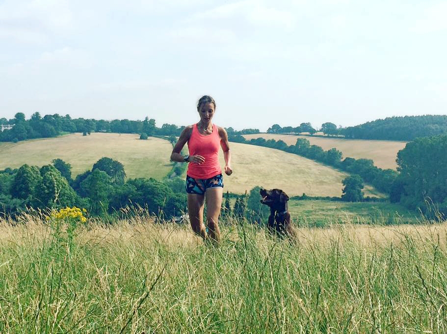 Marathon runner Rachel Dench running up a hill with a dog